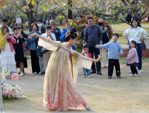 清明假期期間，上海顧村公園櫻花島上，游客在觀賞國(guó)風(fēng)漢服快閃表演。（圖片來(lái)源：視覺(jué)中國(guó)）