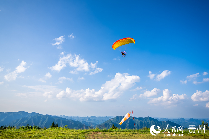 游客在野玉海飛行營(yíng)地乘動(dòng)力滑翔傘體驗(yàn)云端觀景。人民網(wǎng)記者 涂敏攝