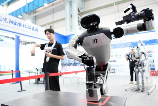 9月5日，在沈陽的2025全球工業(yè)互聯(lián)網(wǎng)大會的展覽區(qū)現(xiàn)場，中國科學(xué)院沈陽自動化研究所的機器人工程師在調(diào)試具身智能操作系統(tǒng)。新華社記者 李鋼 攝